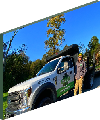 man standing next to a white dump truck with a logo.